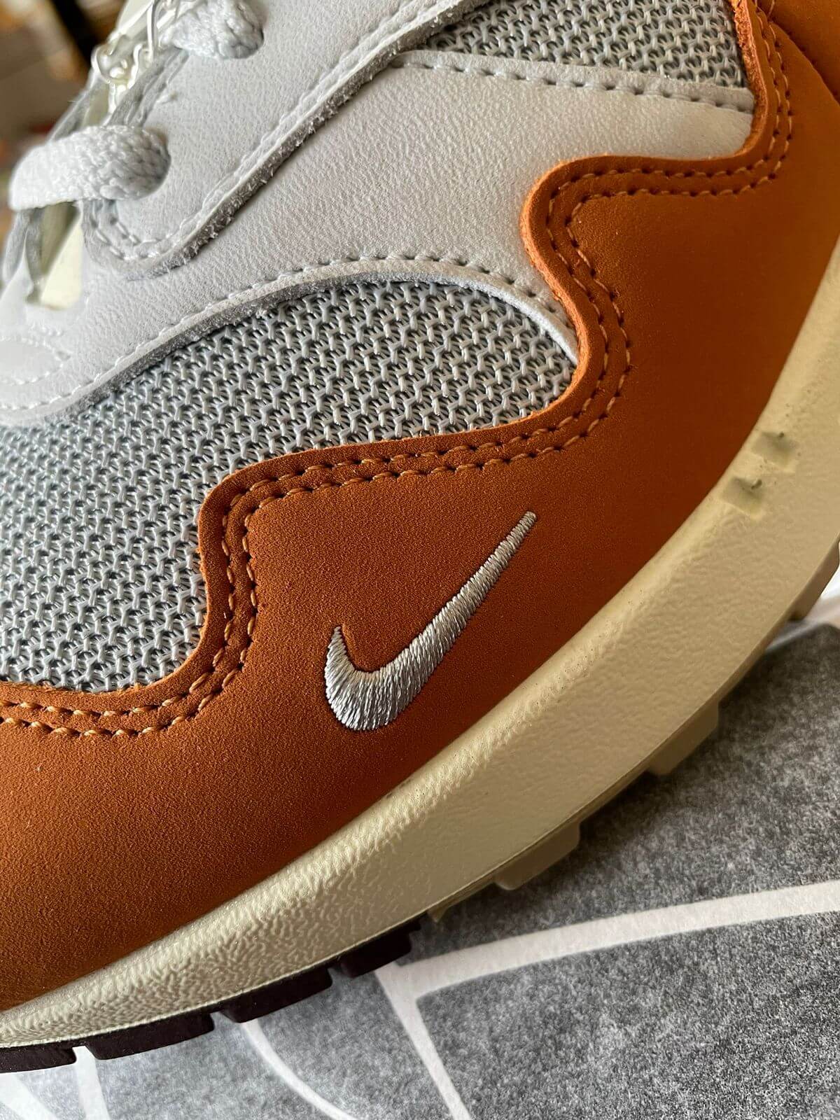 mini swoosh detail on the Nike x Patta - Air Max 1 Waves "Monarch" - metallic silver/monarch-pure platinum - DH1348-001