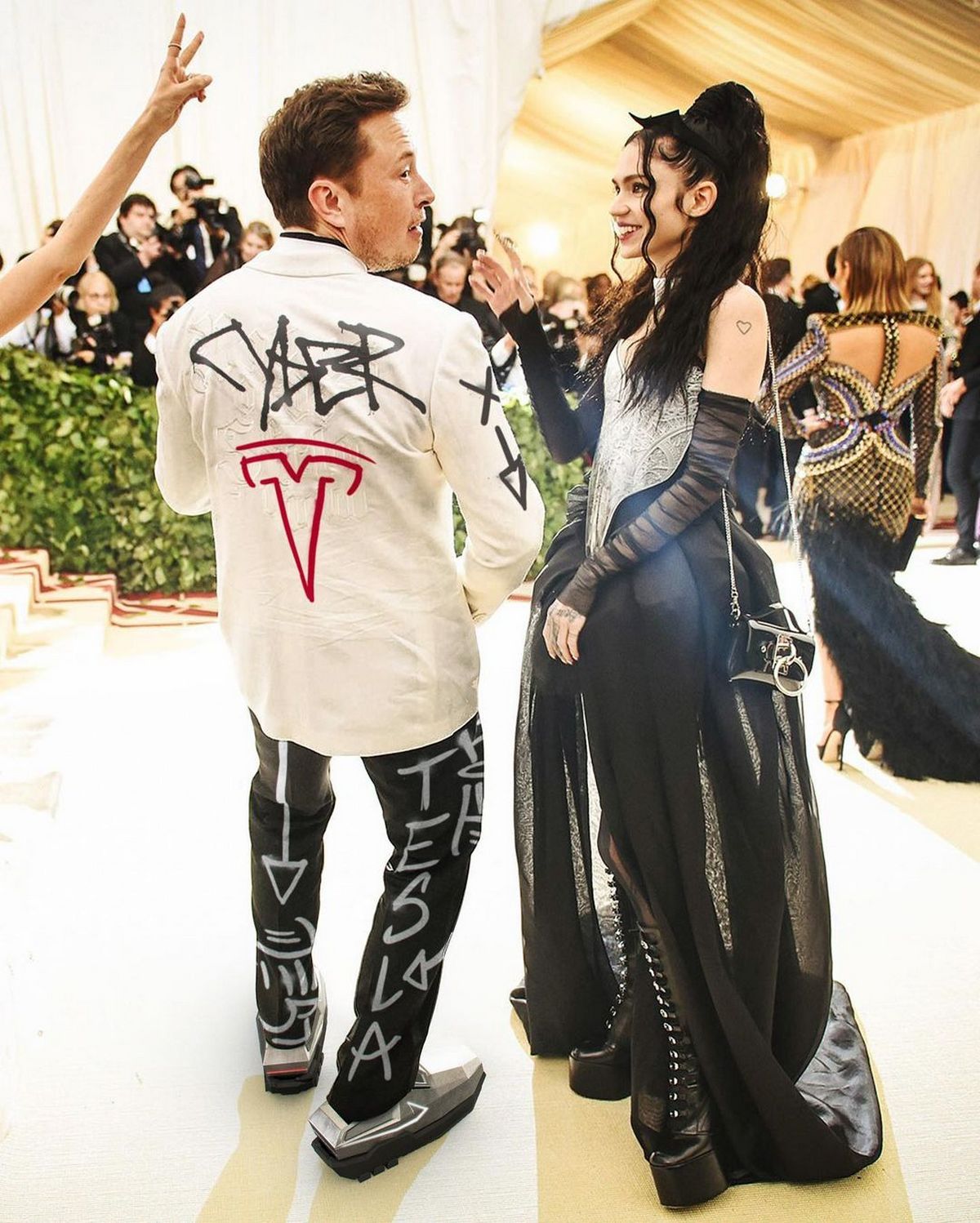 Elon & Grimes. Elon sporting an RTFKT Studio "Cybertruck" Sneaker Design - 2020